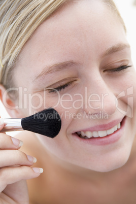 Woman with makeup brush smiling