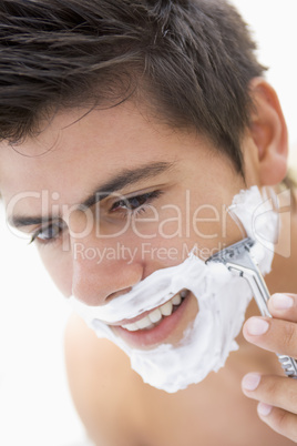 Man shaving and smiling