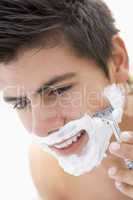 Man shaving and smiling