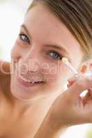 Woman with eyeshadow applicator smiling