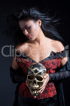 Beautiful brazilian woman holding a skull