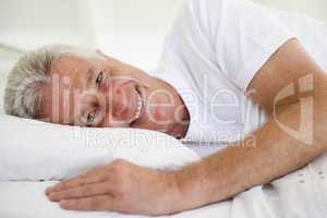 Man lying in bed smiling