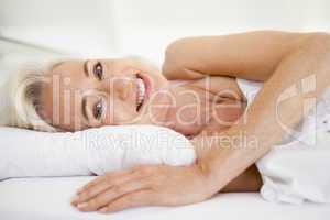 Woman lying in bed smiling