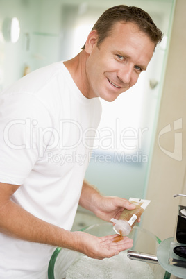 Man in bathroom with hair gel smiling