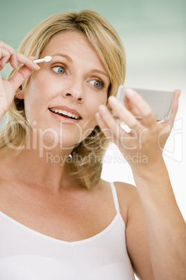 Woman with eyeshadow applicator smiling