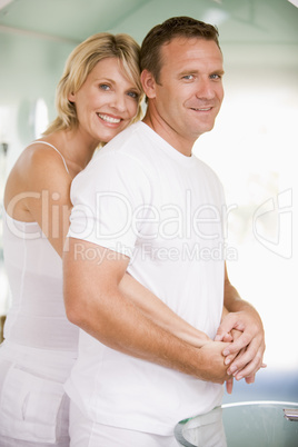 Couple in bathroom embracing and smiling