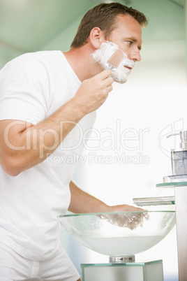 Man in bathroom shaving