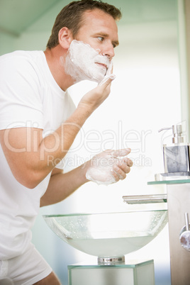 Man in bathroom shaving