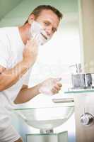 Man in bathroom shaving