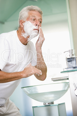 Man in bathroom shaving