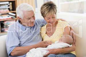 Grandparents in living room with baby smiling