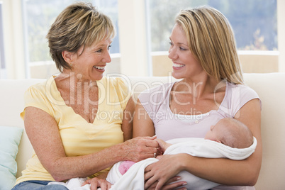 Grandmother and mother in living room with baby smiling