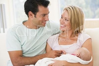 Couple in living room with baby smiling