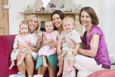 Three mothers in living room with babies smiling