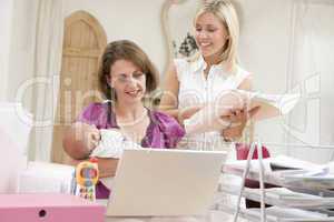 Two women and a baby in home office with laptop