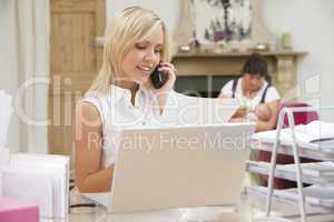 Woman in home office with laptop and telephone with mother and b