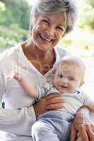 Grandmother outdoors on patio with baby smiling