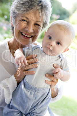 Grandmother outdoors on patio with baby smiling