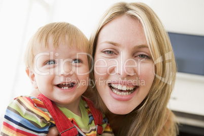 Mother in living room holding baby smiling