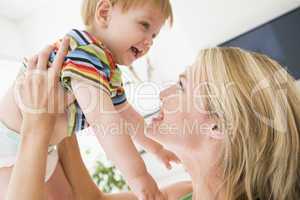 Mother in living room holding baby smiling