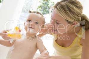 Mother giving baby bubble bath smiling