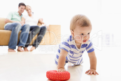 Couple in living room with baby smiling