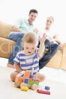 Couple in living room with baby smiling