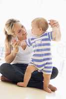 Mother and baby indoors playing and smiling