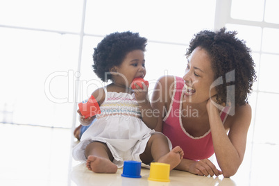 Mother and daughter indoors playing and smiling