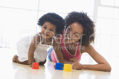 Mother and daughter indoors playing and smiling