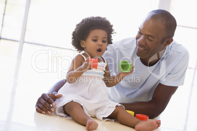 Father and daughter indoors playing and smiling