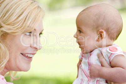 Mother and baby outdoors smiling