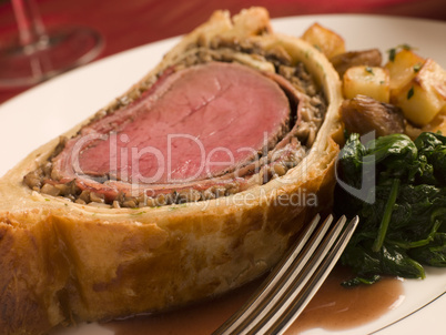 Slice of Beef Wellington with Spinach and Saut ed Potatoes