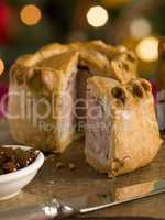 Pork Pie cut on a Board with Chutney