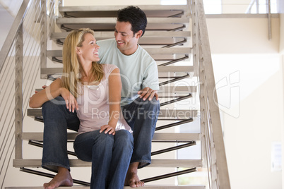 Couple sitting on staircase smiling