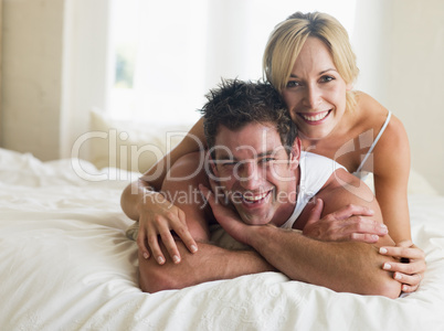 Couple lying in bed smiling