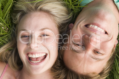 Couple lying in grass smiling