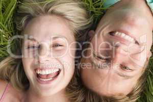 Couple lying in grass smiling