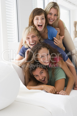 Five people in living room piled up smiling