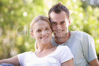 Couple sitting outdoors smiling