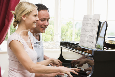 Couple playing piano and smiling