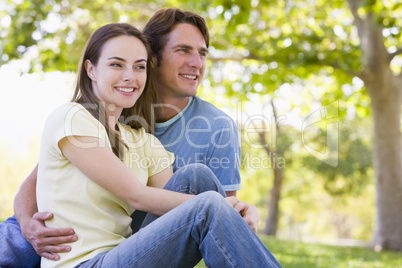 Couple sitting outdoors smiling