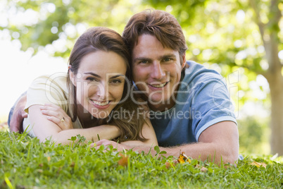 Couple lying outdoors smiling