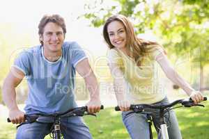 Couple on bikes outdoors smiling