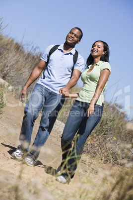 Couple walking on path holding hands and smiling