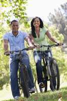 Couple on bikes outdoors smiling