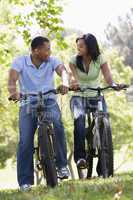 Couple on bikes outdoors smiling