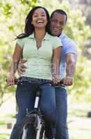 Couple on a bike outdoors smiling