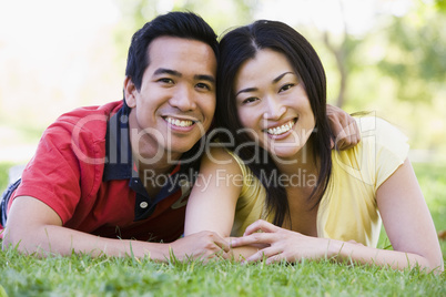 Couple lying outdoors smiling