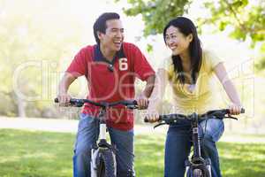 Couple on bikes outdoors smiling